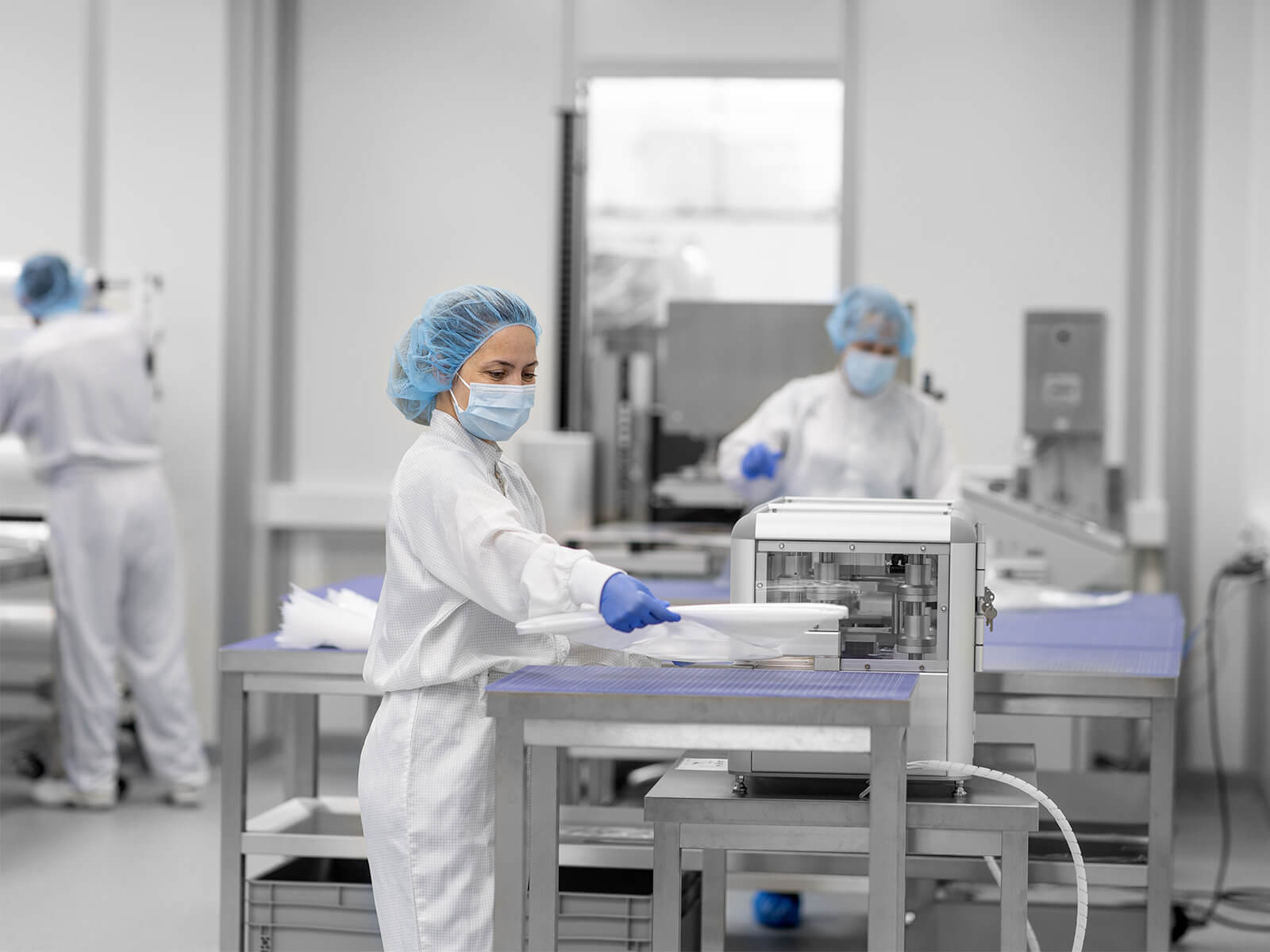 Une employée de laboratoire déroule un film dans une usine