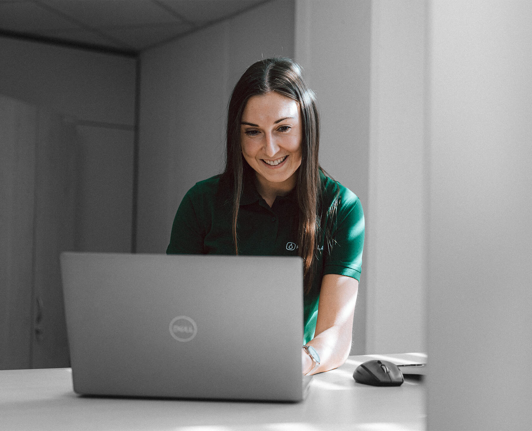 Mujer feliz delante de un portátil gris